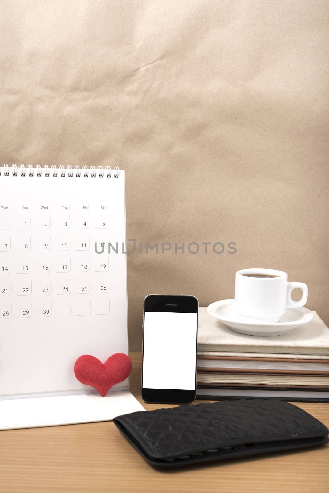 office desk : coffee with phone,wallet,calendar,heart,stack of book on wood background