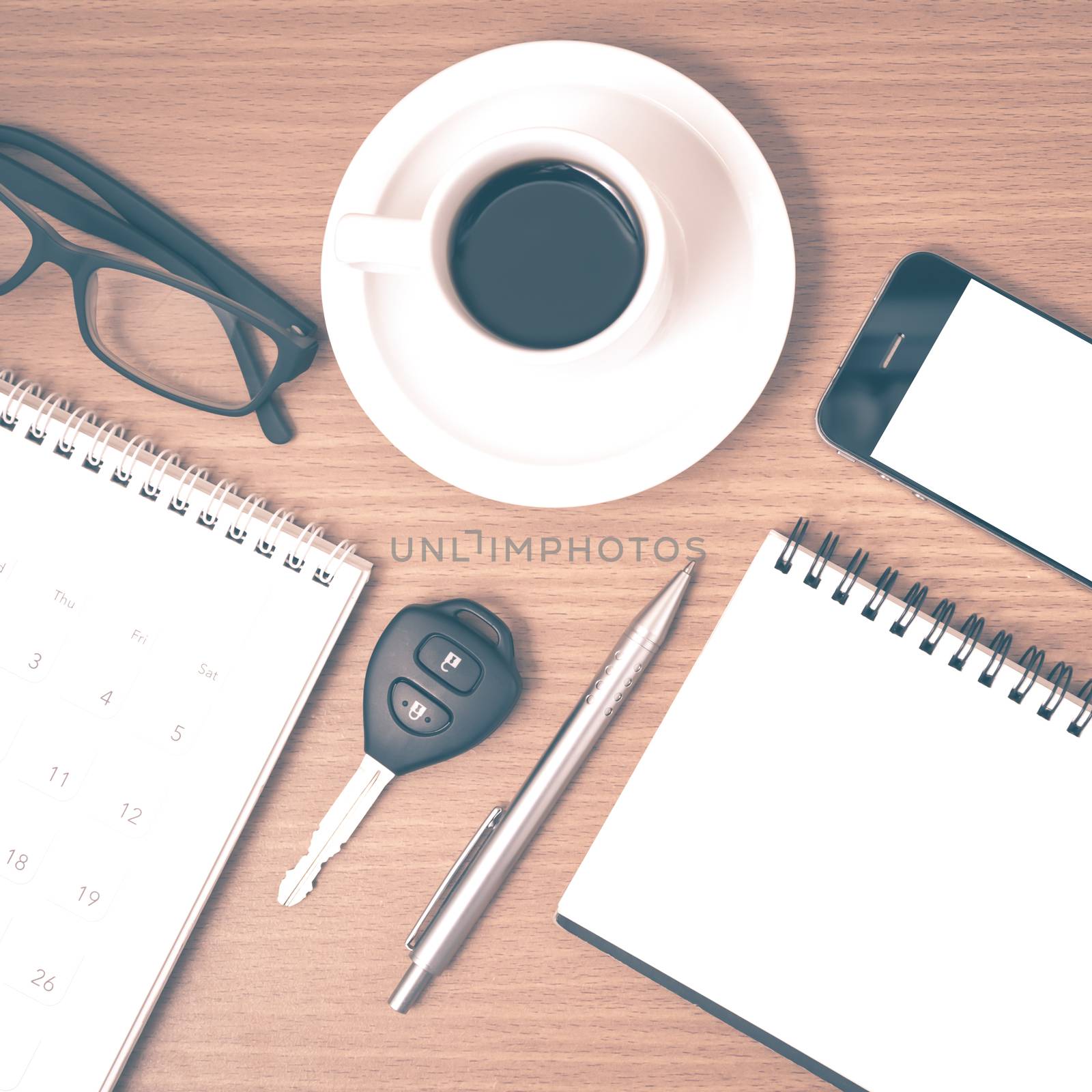 coffee and phone with car key,eyeglasses,notepad,calendar on wood background vintage style