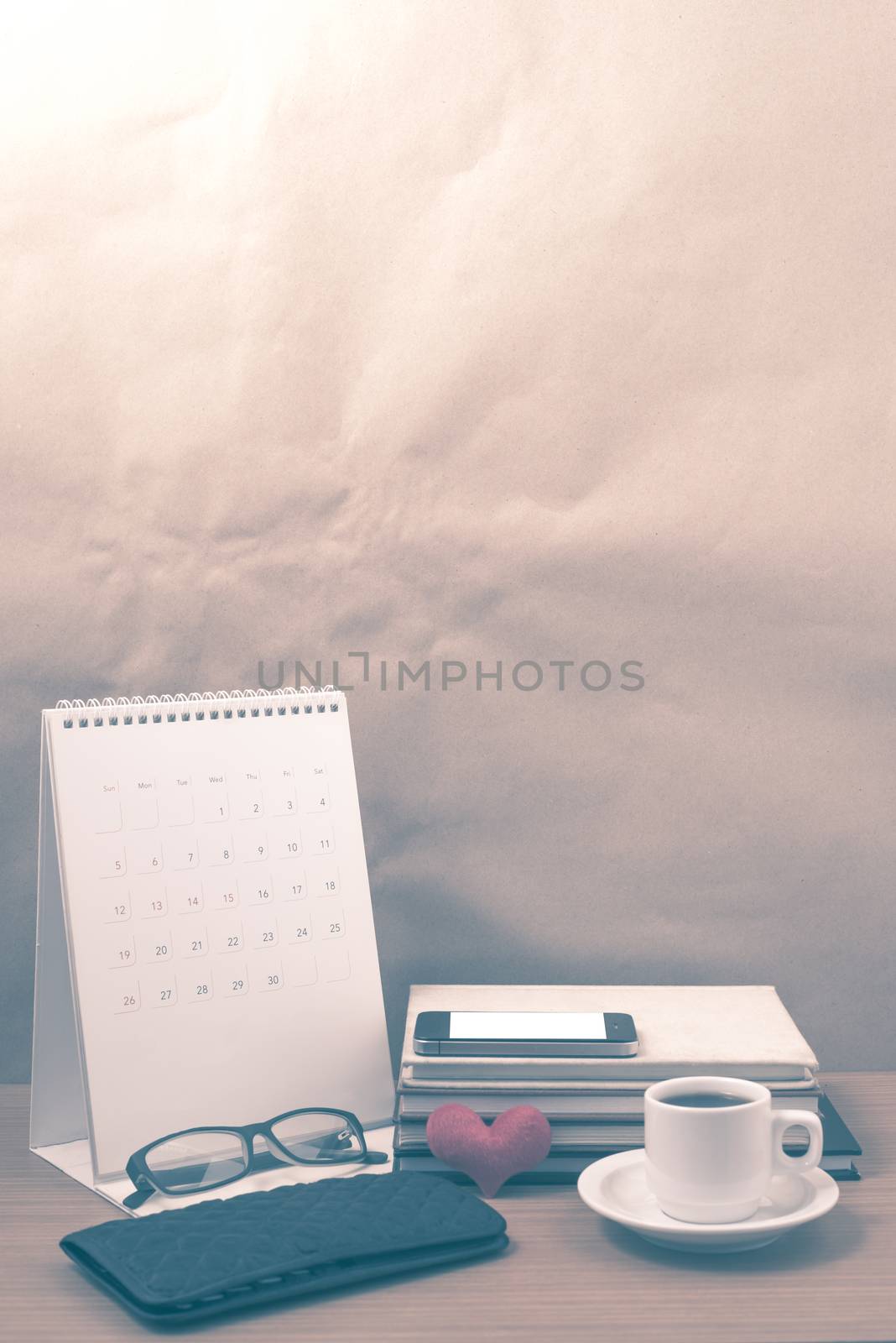 desktop : coffee with phone,stack of book,wallet,heart,eyeglasses,calendar on wood background vintage style