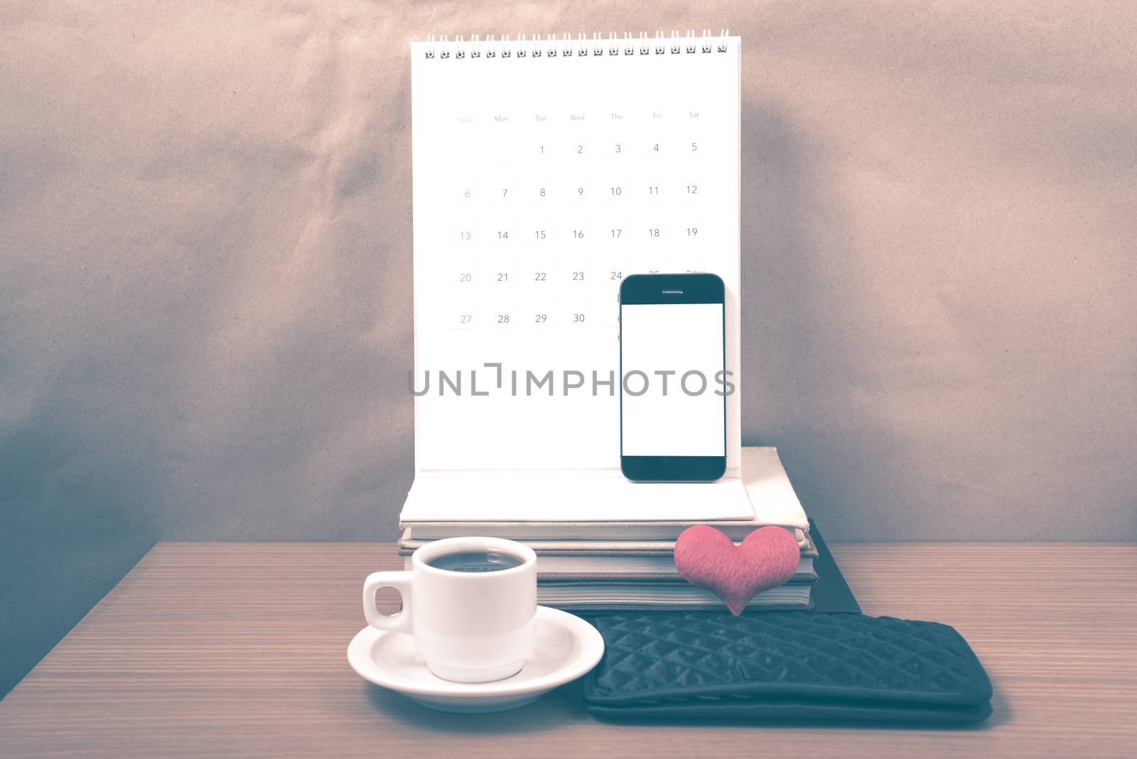 office desk : coffee with phone,wallet,calendar,heart,stack of book on wood background vintage style