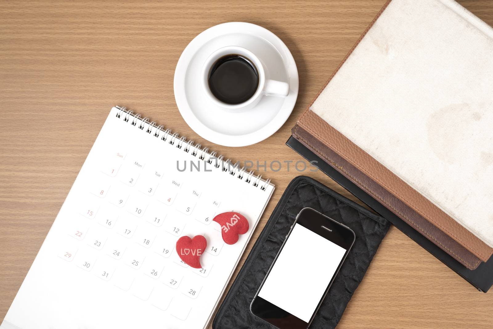 office desk : coffee with phone,wallet,calendar,heart,stack of book on wood background