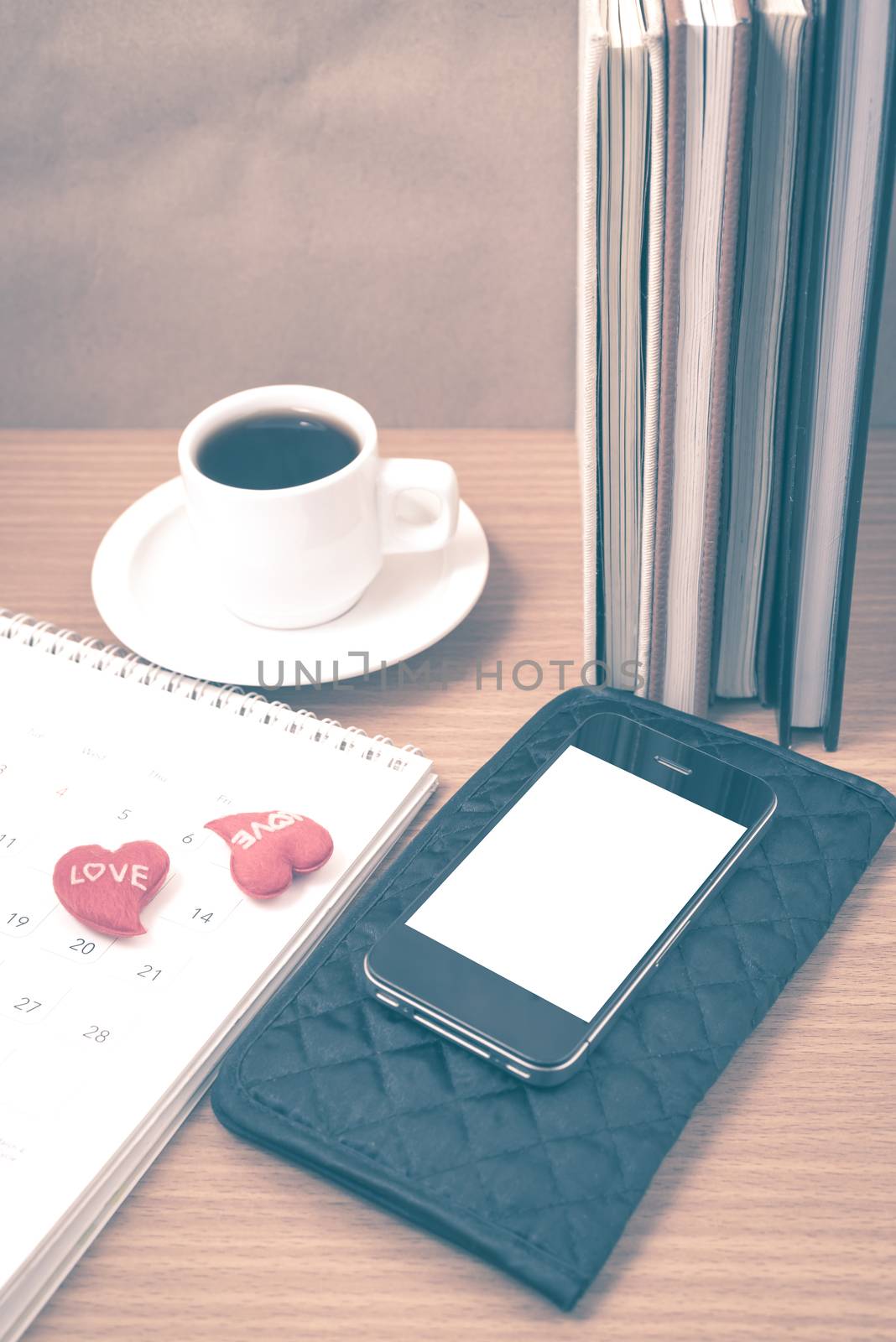 office desk : coffee with phone,wallet,calendar,heart,stack of book on wood background vintage style