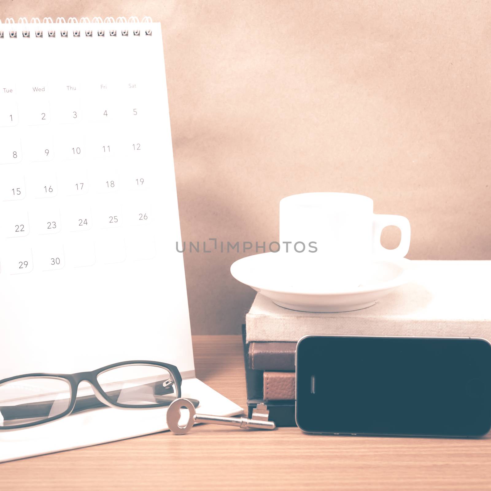 coffee and phone with key,eyeglasses,stack of book,calendar on wood background vintage style