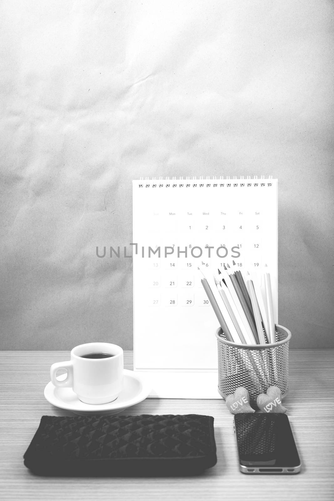 office desk : coffee with phone,wallet,calendar,heart,color pencil box on wood background black and white color