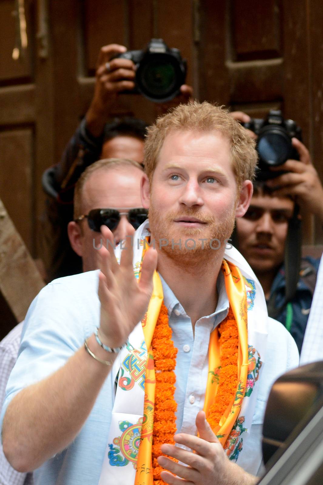NEPAL, Kathmandu : Britain's Prince Harry (C) waves as he walks with officials as he visits heritage sites in Patan Durbar Square on the outskirts of Kathmandu on March 20, 2016. Britain's Prince Harry arrived in Nepal for a five-day visit and said he hopes to shine a spotlight on resilience of Nepali people recovering from last year's devastating quake. 