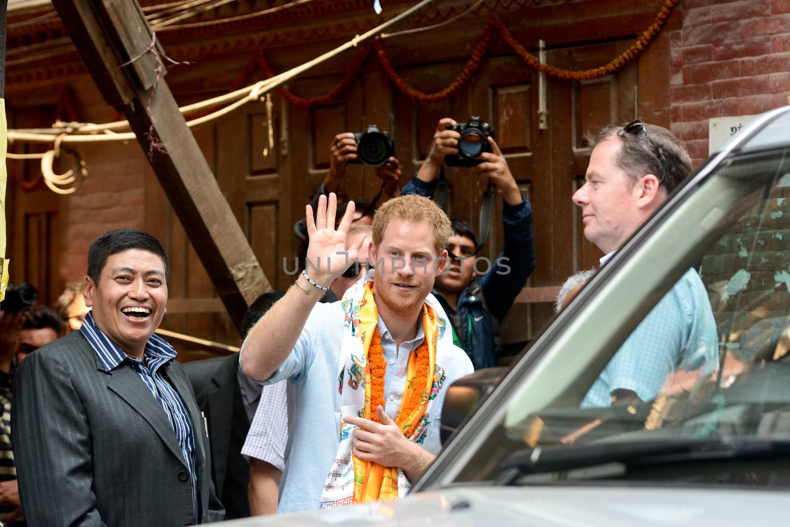 NEPAL, Kathmandu : Britain's Prince Harry (C) waves as he walks with officials as he visits heritage sites in Patan Durbar Square on the outskirts of Kathmandu on March 20, 2016. Britain's Prince Harry arrived in Nepal for a five-day visit and said he hopes to shine a spotlight on resilience of Nepali people recovering from last year's devastating quake. 