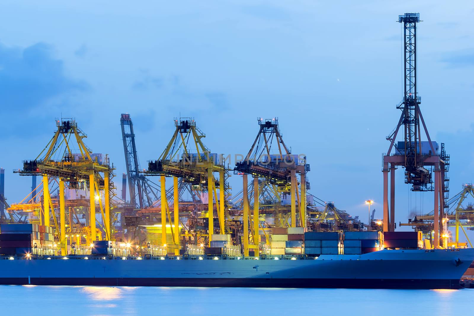 Loading and unloading containers at Port of Singapore during evening