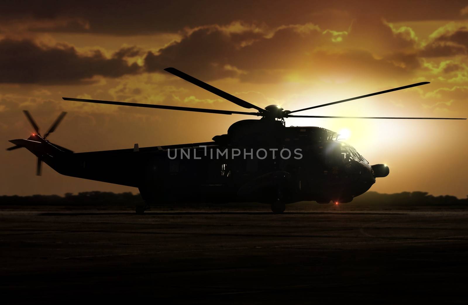 Military helicopter on airfield during sunset by razihusin