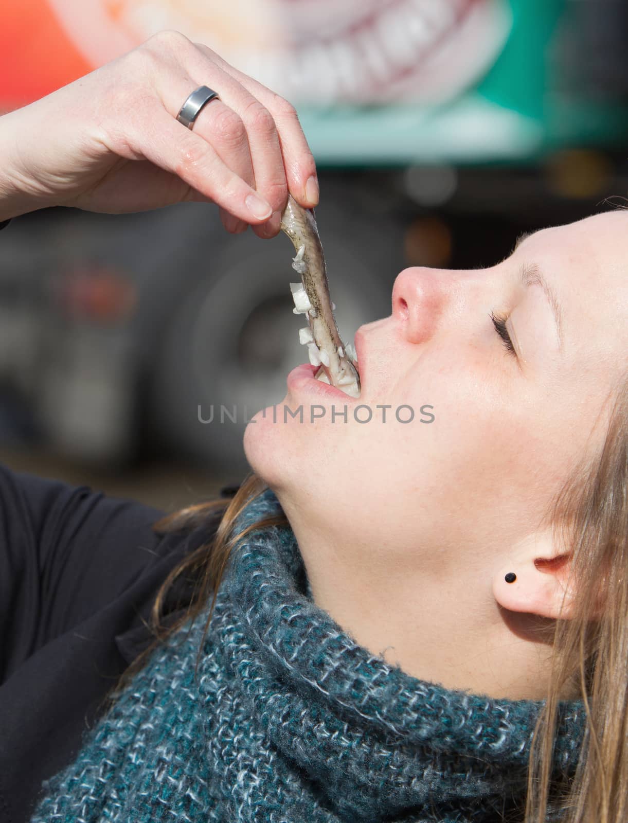 Dutch woman is eating typical raw herring by michaklootwijk