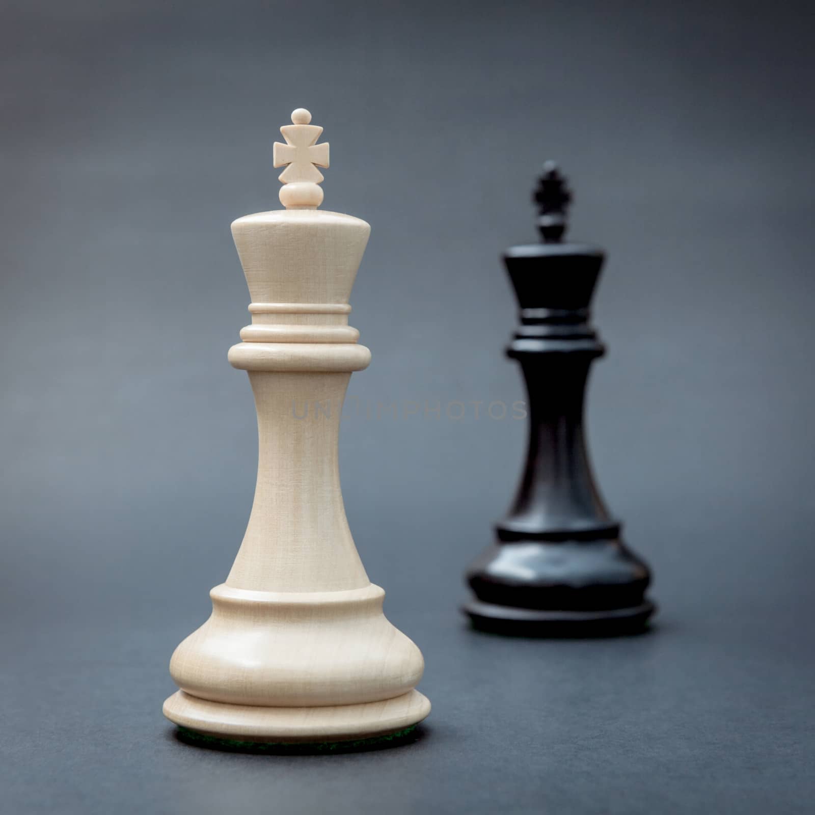 Black and white king of chess set up on dark background .