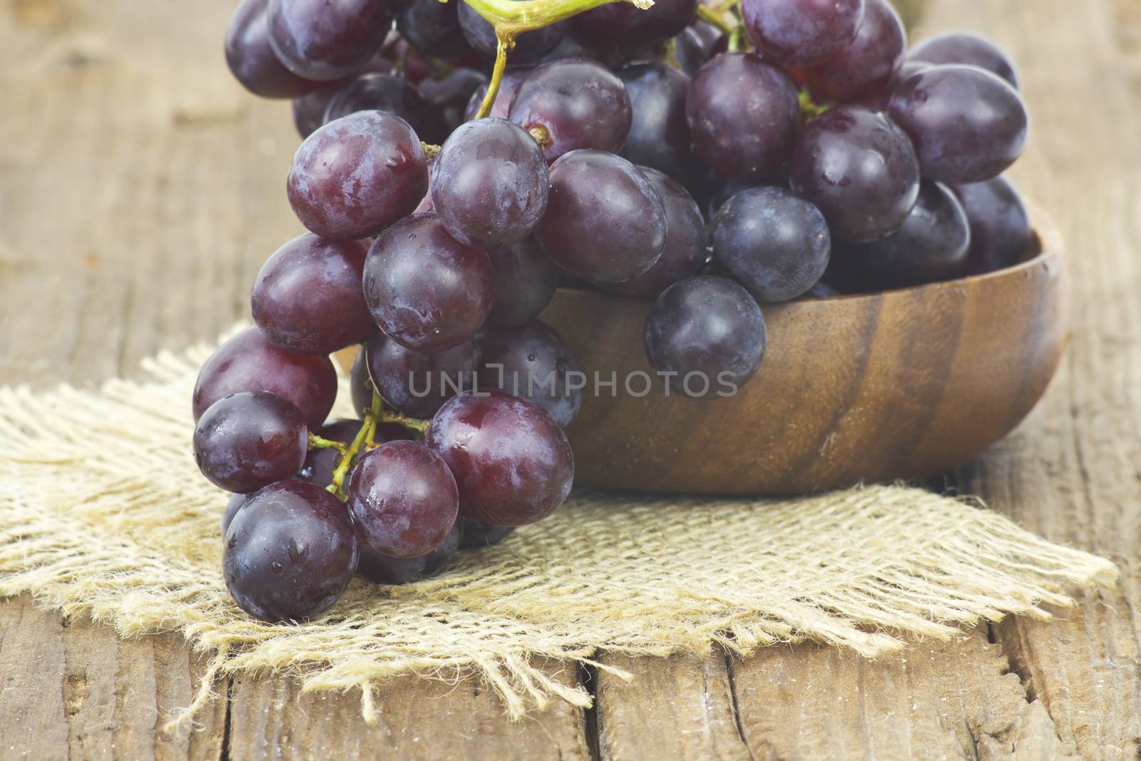 grapes in a bowl on wooden background