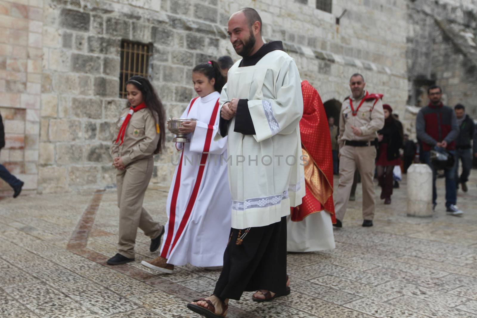 WEST BANK, Bethlehem: Palestinian Catholics walk to the Church of the Nativity Compound, to celebrate the Palm Sunday on March 20, 2016 in the West Bank city of Bethlehem. Palm Sunday marks the triumphant return of Jesus Christ to Jerusalem when a cheering crowd greeted him waving palm leaves, a week before his crucifixion.