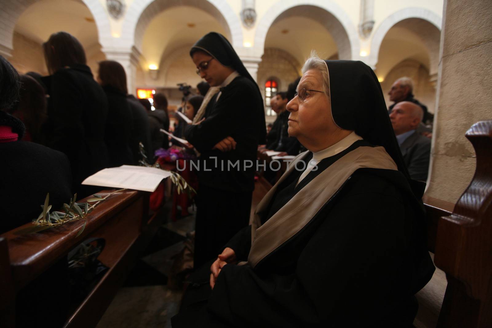 WEST BANK, Bethlehem: Palestinian Catholics pray inside the Church of the Nativity Compound, to celebrate the Palm Sunday on March 20, 2016 in the West Bank city of Bethlehem. Palm Sunday marks the triumphant return of Jesus Christ to Jerusalem when a cheering crowd greeted him waving palm leaves, a week before his crucifixion.