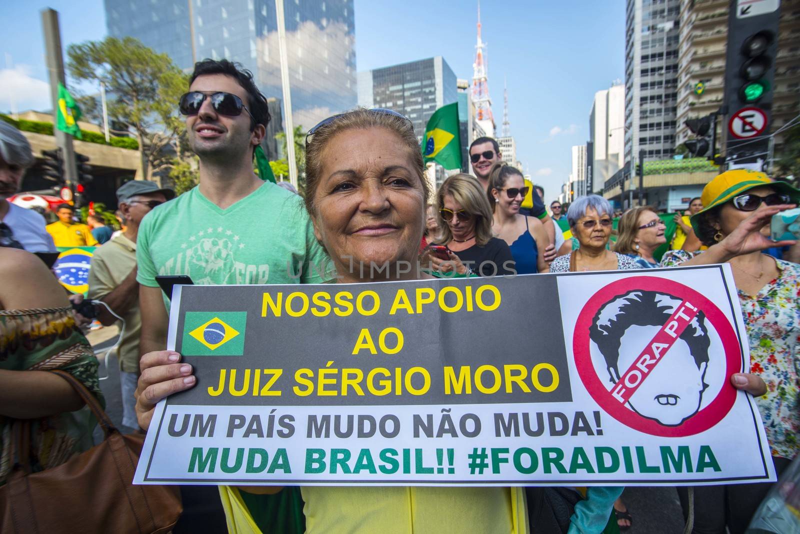 BRAZIL, Sao Paulo: A woman holds a placard which reads 'Our support to Judge Sergio Moro. A dumb country does not change. Let's change, Brazil! Dilma out' as thousands of protesters demonstrate against Brazilian former president (2003-2011) Luiz Inacio Lula da Silva in Sao Paulo, on March 20, 2016. Brazilian lawmakers relaunched impeachment proceedings against President Dilma Rousseff Thursday and a judge blocked her bid to bring her powerful predecessor into her cabinet, intensifying the political crisis engulfing her.