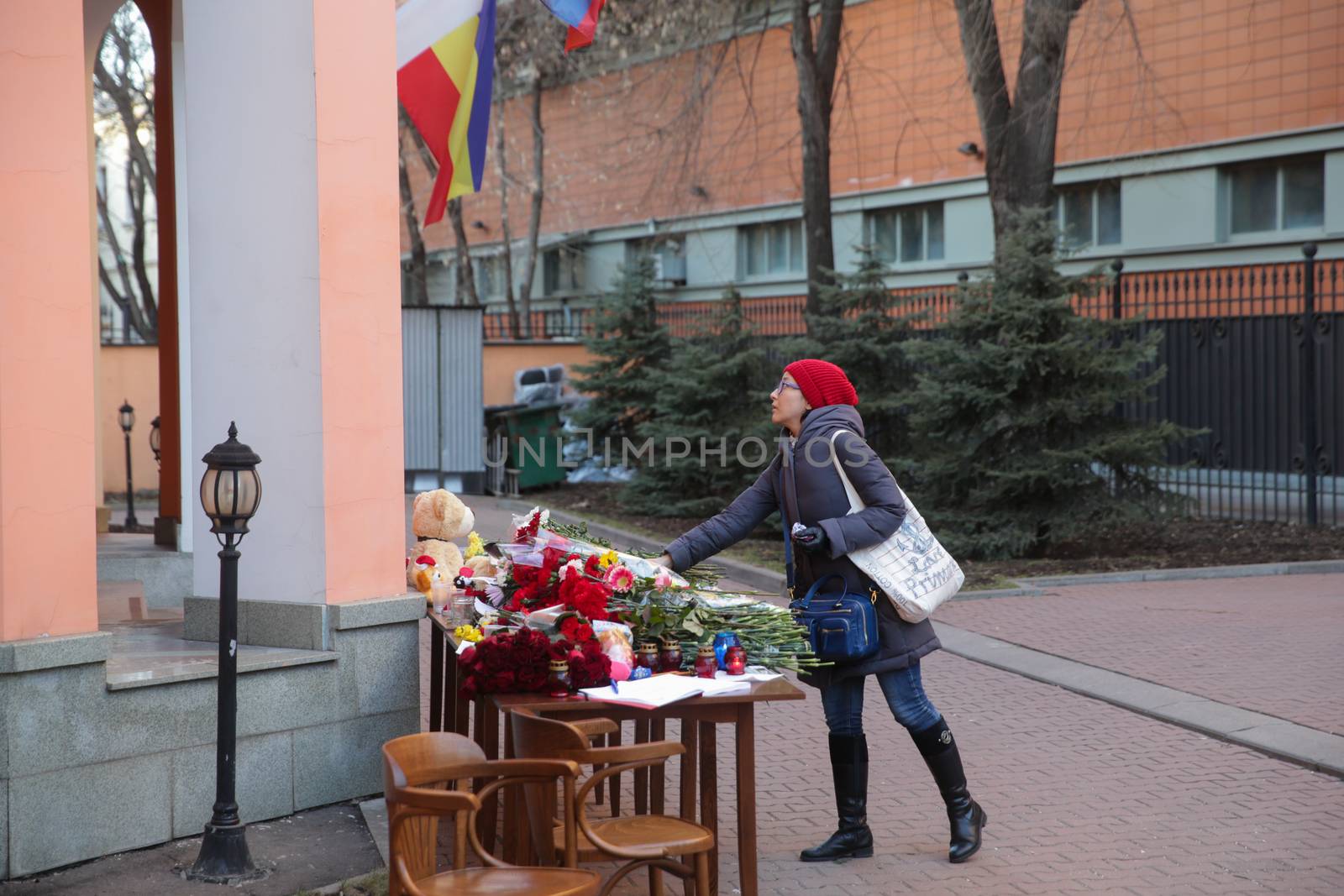 RUSSIA, Moscow: A woman drops off flowers pay tribute to Boeing-737-800 crash victims  at the Moscow representative office of Rostov-on-Don city, on March 20, 2016 where passenger plane Boeing-737-800 crashed at landing. The plane crashed in southern Russia early on March 19, killing all 62 people on board as it tried to land in bad weather in the city of Rostov-on-Don.