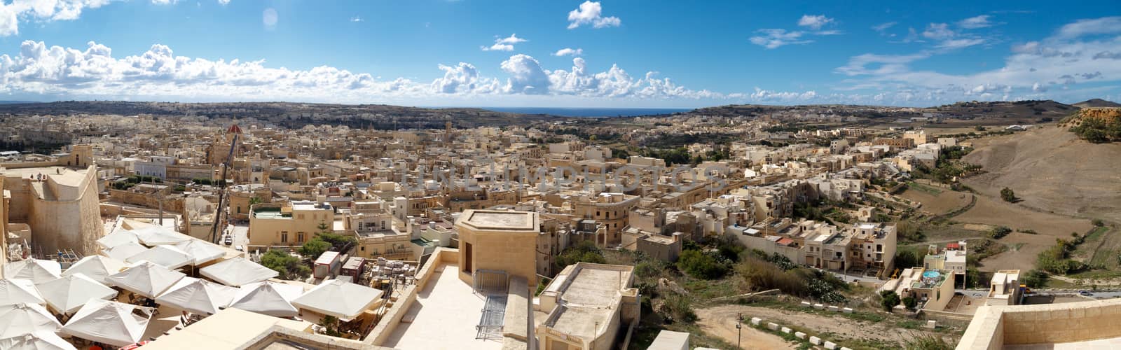 VICTORIA, MALTA - OCTOBER 31, 2015 : View of Victoria city in Malta, with historical limestone buildings, on cloudy blue sky background.