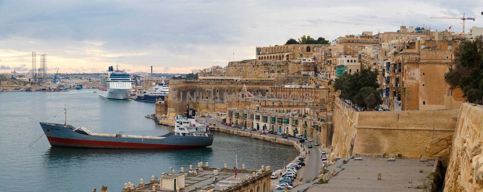 VALLETTA, MALTA - OCTOBER 30, 2015 : View of Valletta with ships and boats on coastline, on cloudy sky background.
