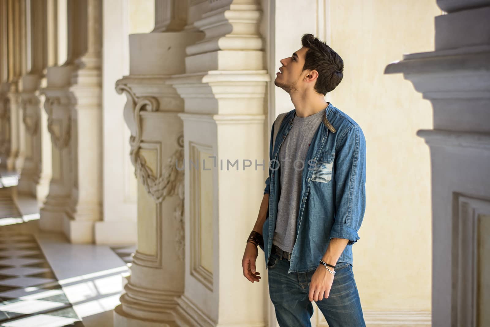 Half Body Shot of a Thoughtful Handsome Young Man, Looking Away Inside a Museum
