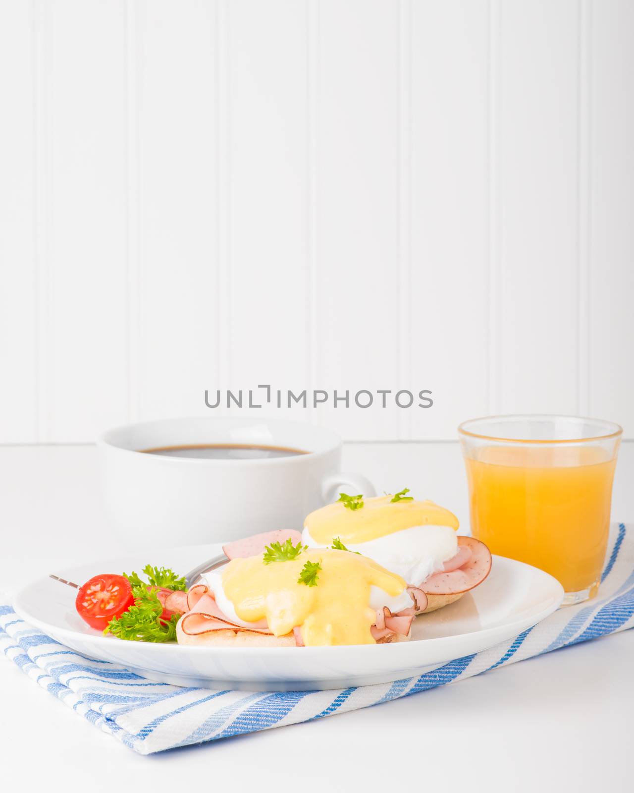 Delicious eggs benedict served with fresh coffee and juice.