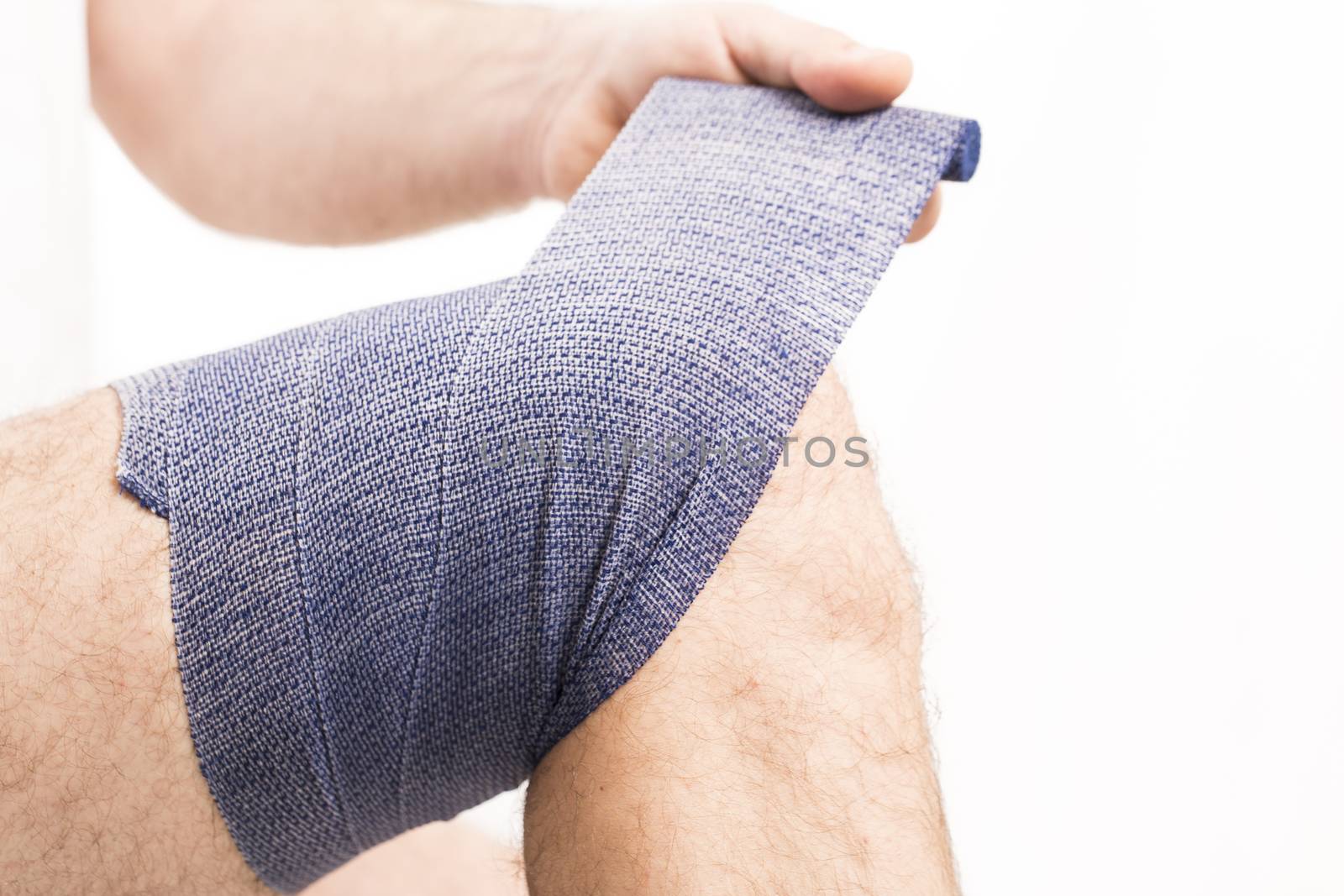 man putting  elastic bandage on knee pain health France