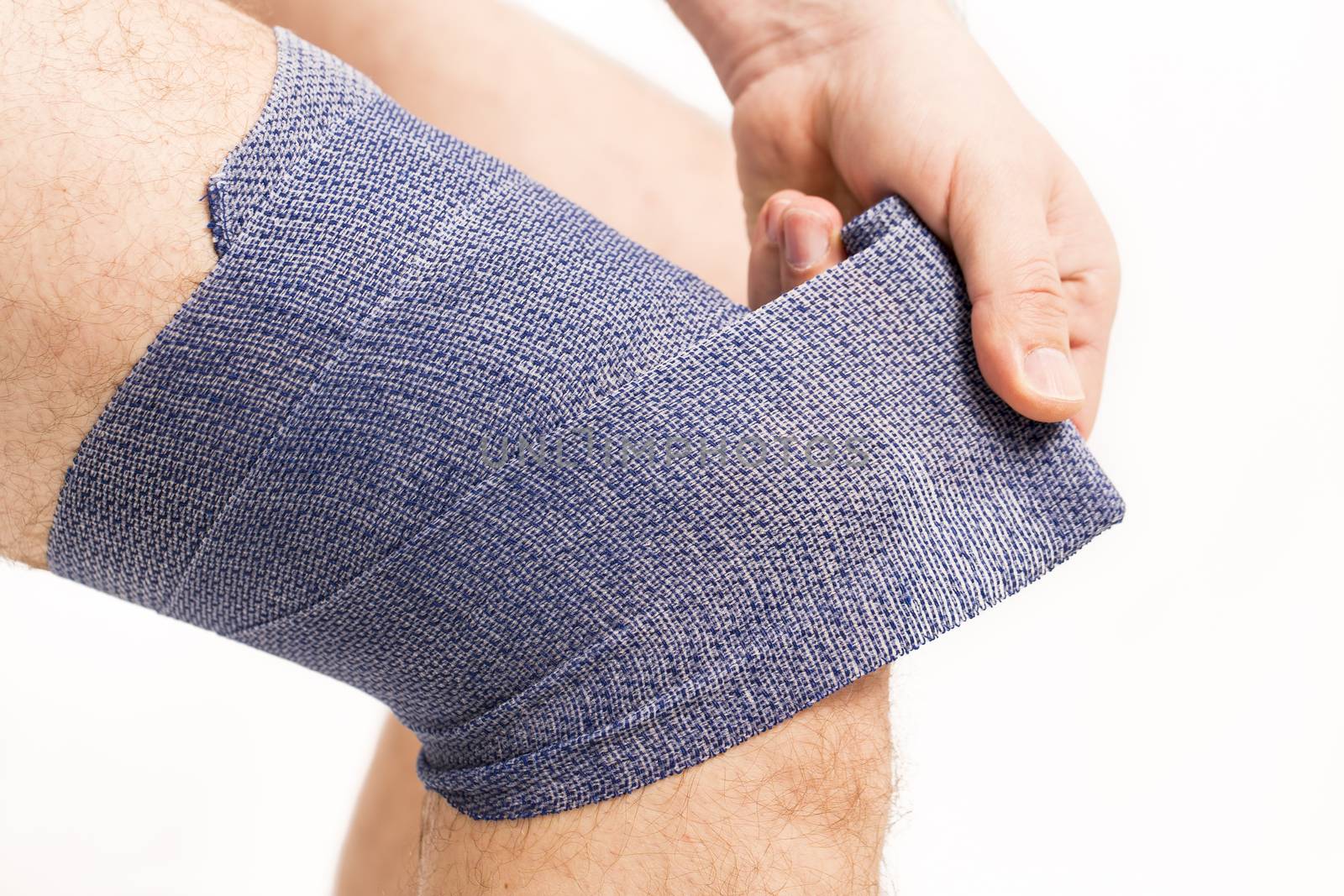 man putting  elastic bandage on knee pain health France