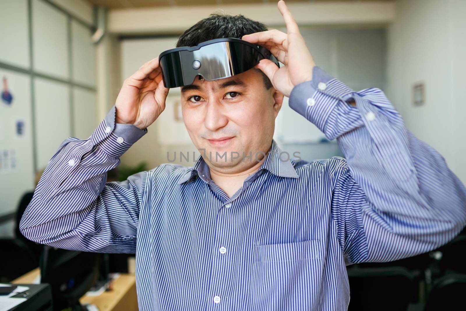 The man wears glasses virtual reality, inside the office.