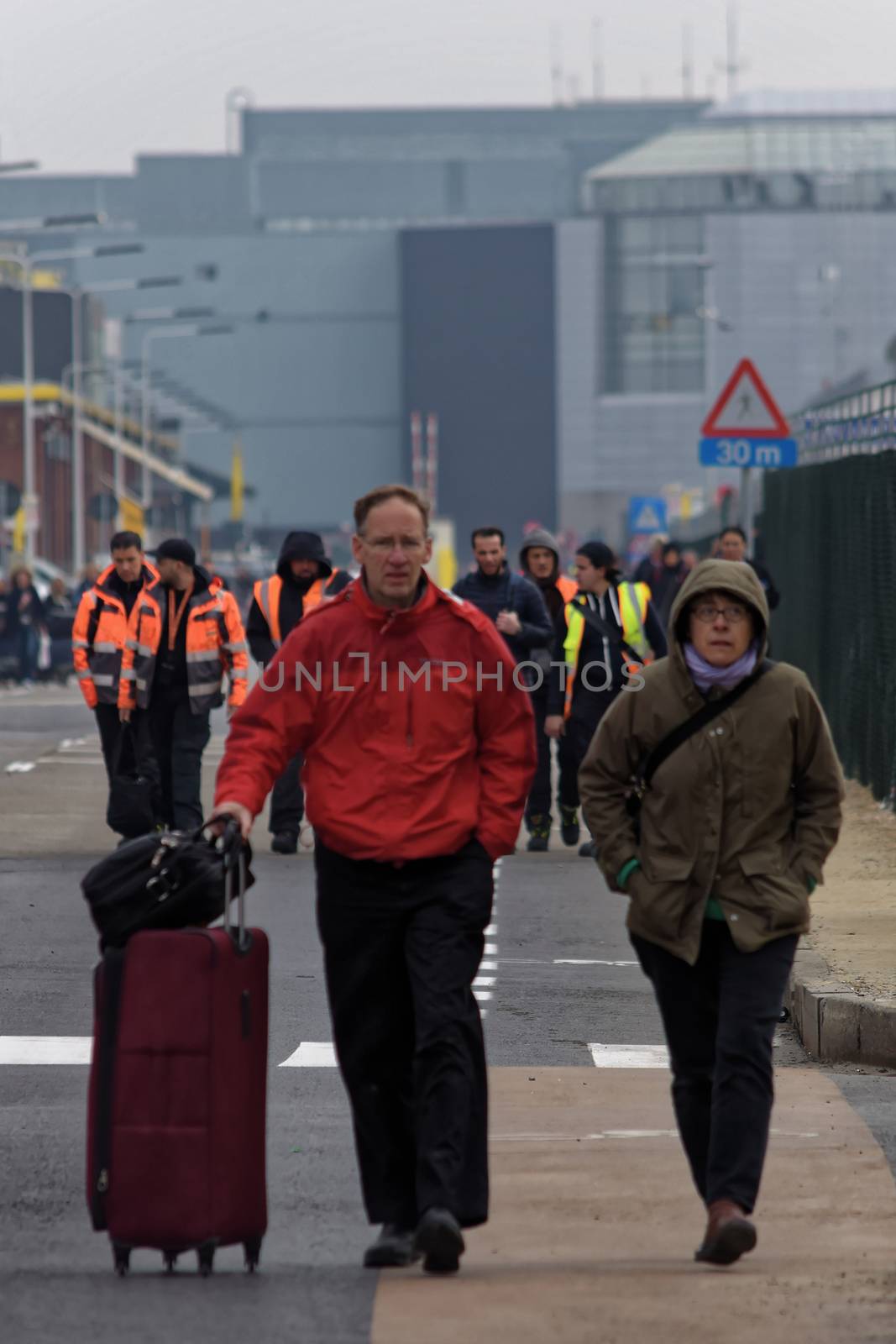 BELGIUM, Brussels: Passengers leave Brussels airport, on March 22, 2016 in Zaventem , following its evacuation after at least 13 people were killed and 35 injured as twin blasts rocked the main terminal of Brussels airport.