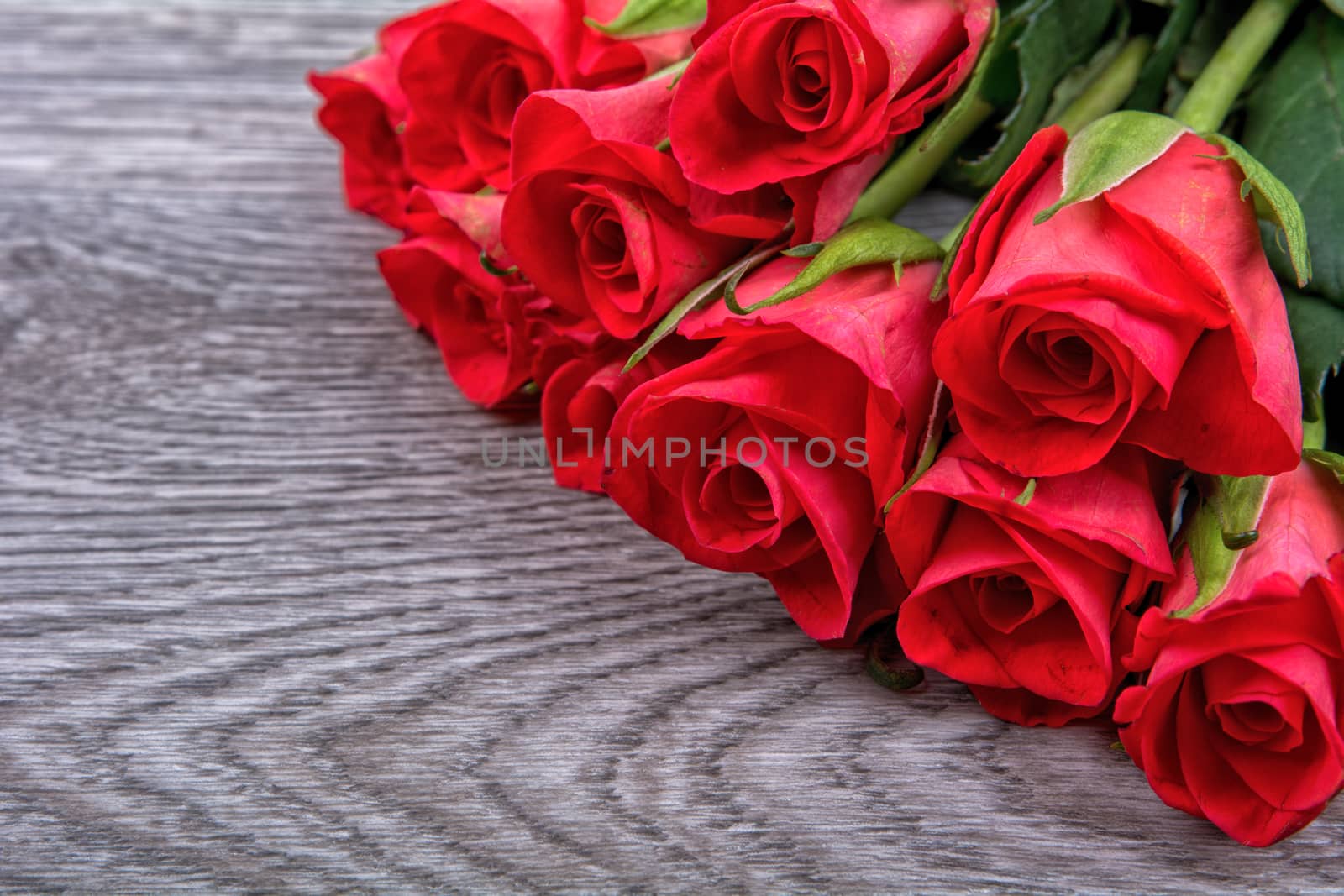 Red roses on a grey wooden background