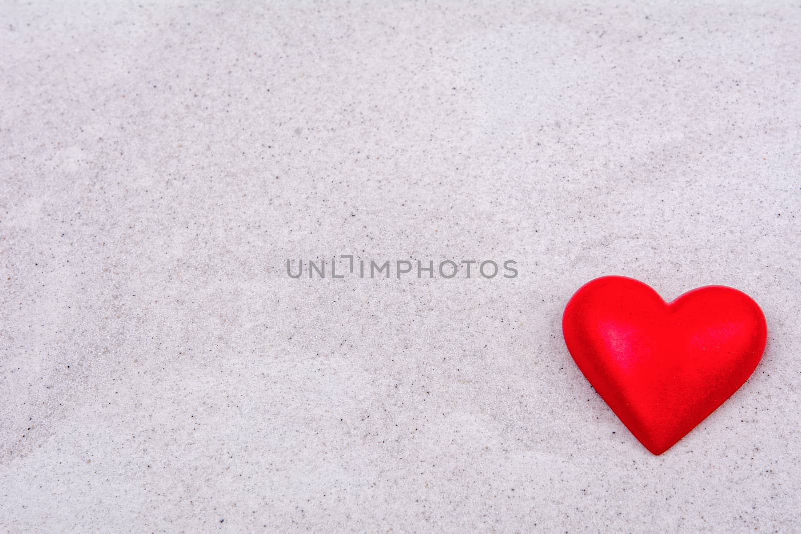 Red heart on a sand background by neryx