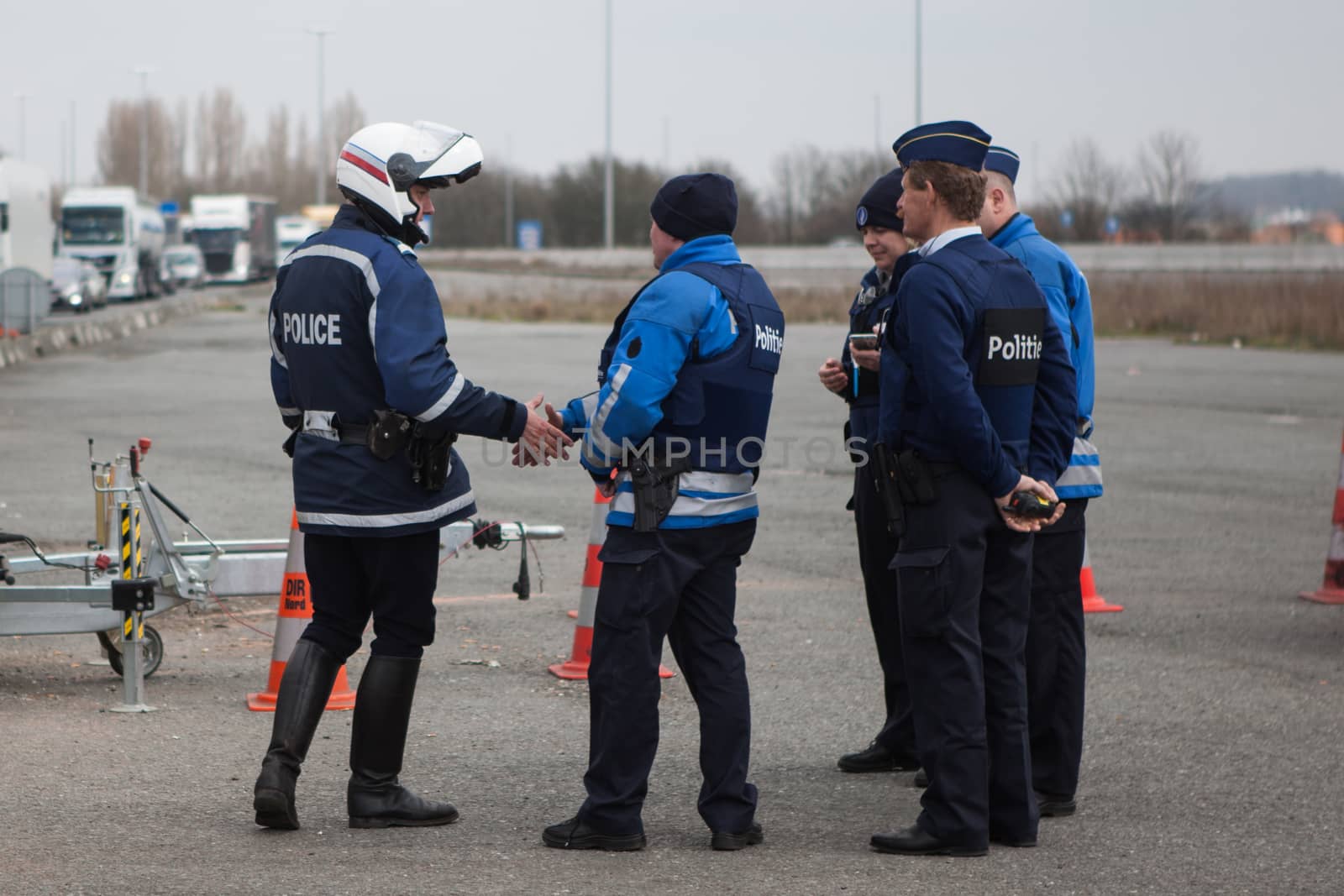 FRANCE, Neuville-en-Ferrain: Belgian police officers shake hands with French police officers as they check vehicles at the French-Belgian border, near Neuville-en-Ferrain, northern France, on March 22, 2016 , as security measures have been reinforced after a series of apparently coordinated explosions ripped through Brussels airport and a metro train on Tuesday, killing at least 26 people in the latest attacks to target Europe.