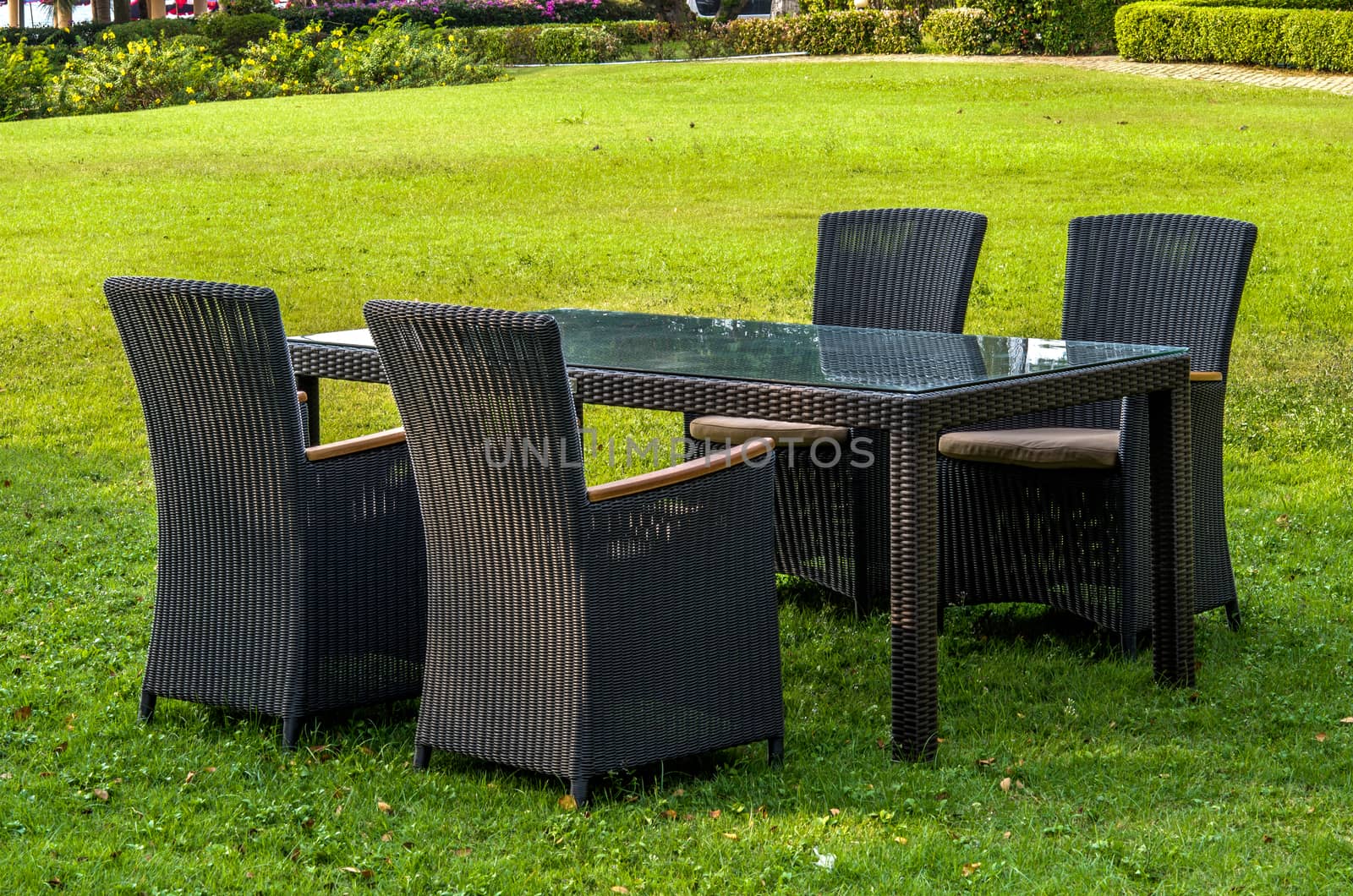 Rattan furniture, table, chairs and cushion outdoors in the garden