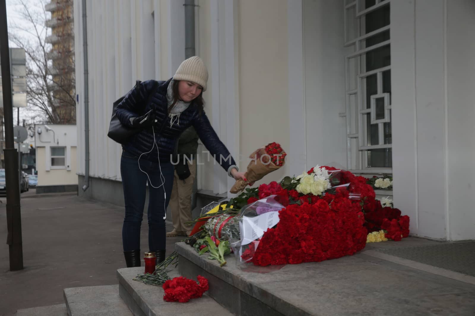 RUSSIA, Moscow: A woman adds to the makeshift memorial outside the Belgian Embassy in Moscow, Russia, following the terror attacks that left at least 30 dead and hundreds injured in Brussels, Belgium on March 22, 2016. The Islamic State terror group has taken responsibility for the attacks, which brought death and destruction on Zaventem airport and Maelbeek metro station.