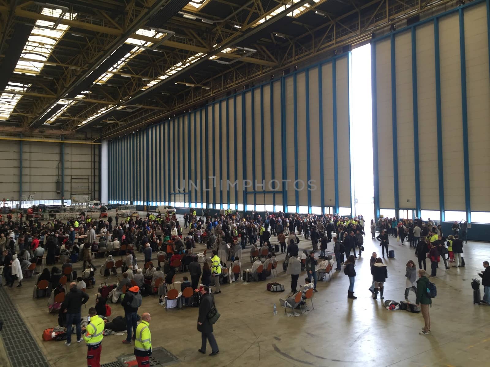 BELGIUM, Brussels: Passengers sit stranded in a hangar at Zaventem airport on March 22, 2016, after terrorist bombings killed at least 30 people, both at the airport and at Maelbeek metro station.Pictures show hundreds of passengers stranded after the attack.
