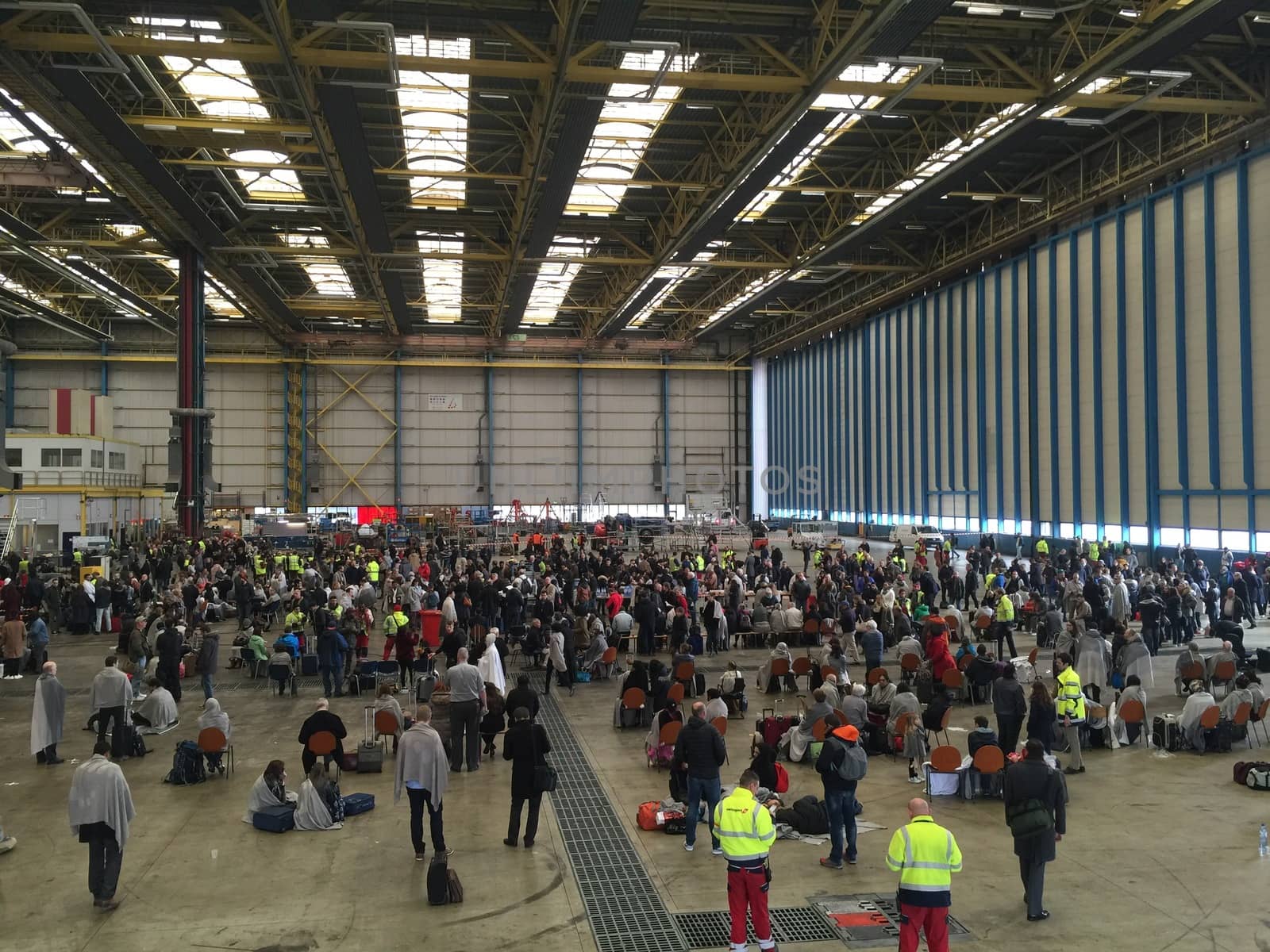 BELGIUM, Brussels: Passengers sit stranded in a hangar at Zaventem airport on March 22, 2016, after terrorist bombings killed at least 30 people, both at the airport and at Maelbeek metro station.Pictures show hundreds of passengers stranded after the attack.
