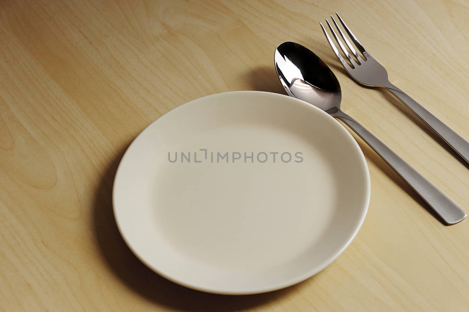 Table with empty  plate and spoon and fork