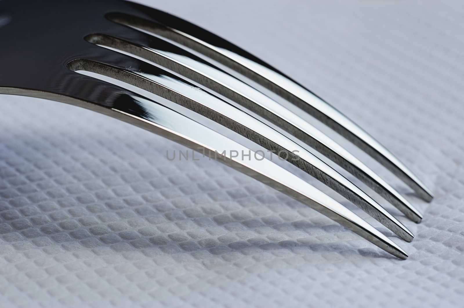 close up of shiny fork on white napkin