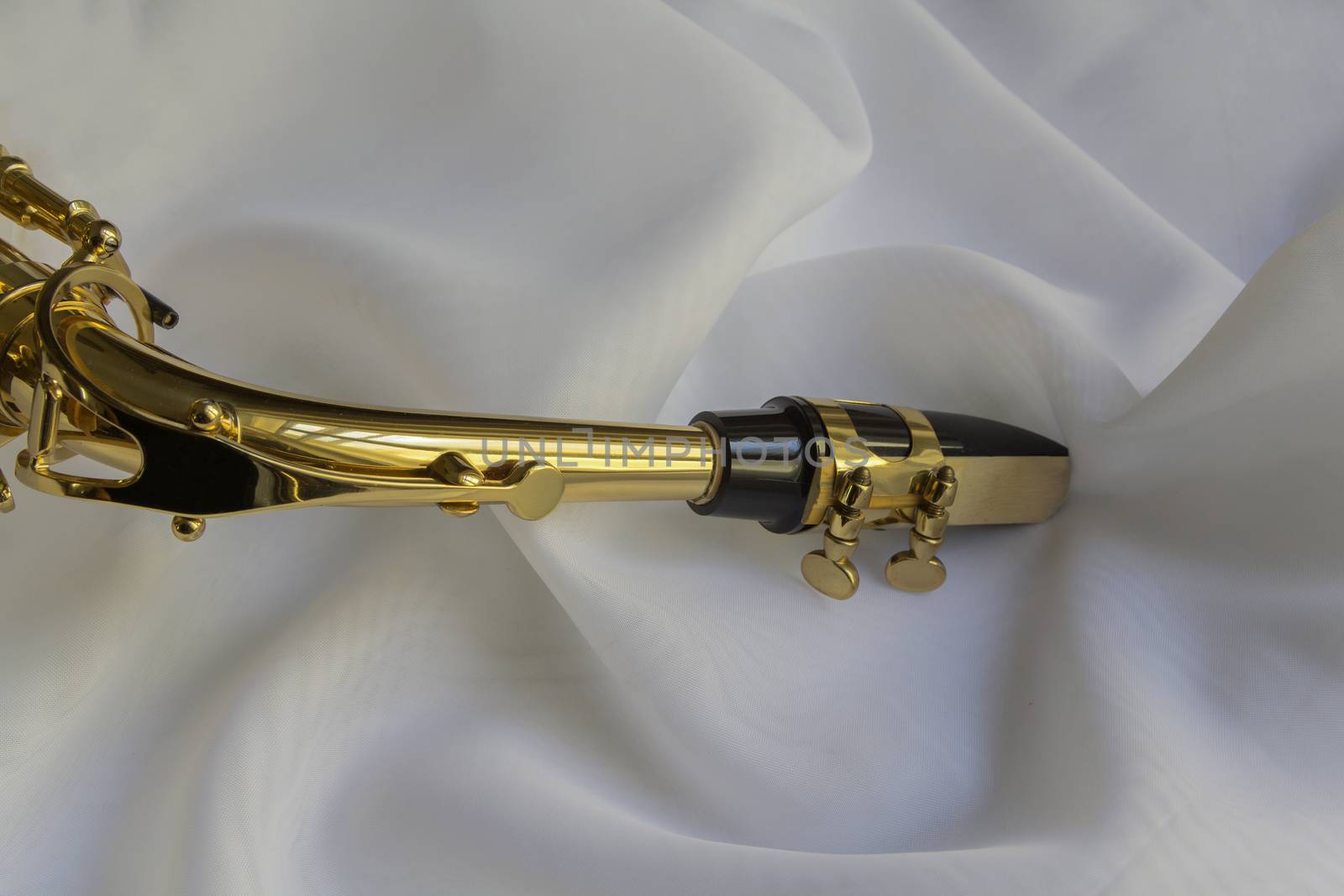 beautiful golden saxophone on delicate White silk background