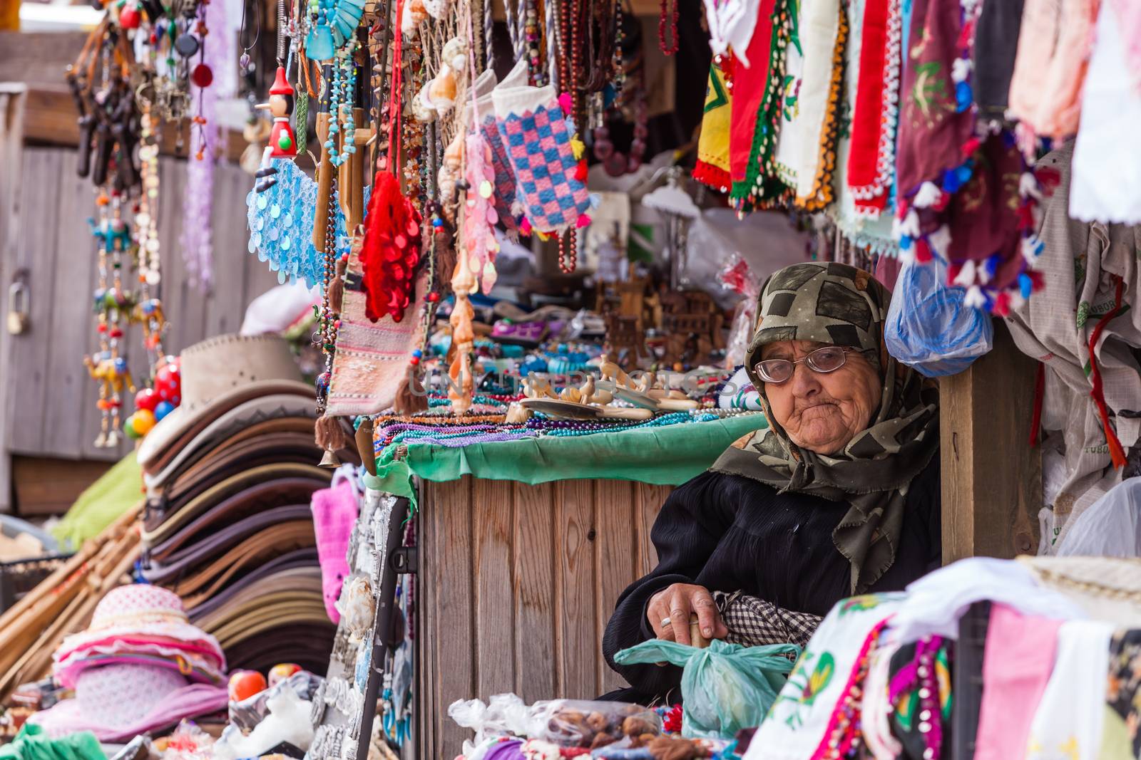 ASSOS, TURKEY – APRIL 23: Unidenified woman selling trinkets and souvenirs during buildup to Anzac Day on April 23, 2012 in Assos, Turkey. 