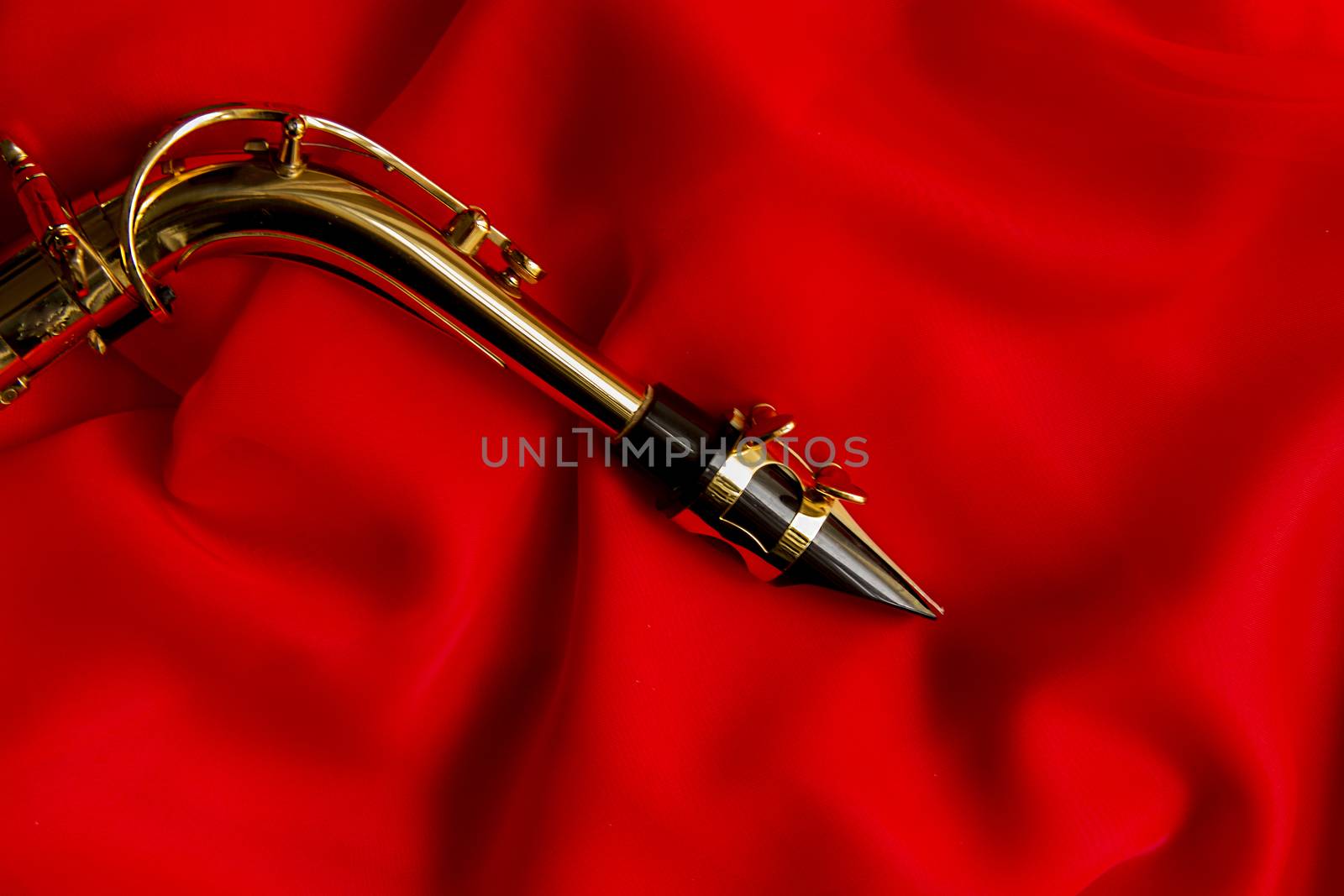beautiful golden saxophone on delicate red silk background
