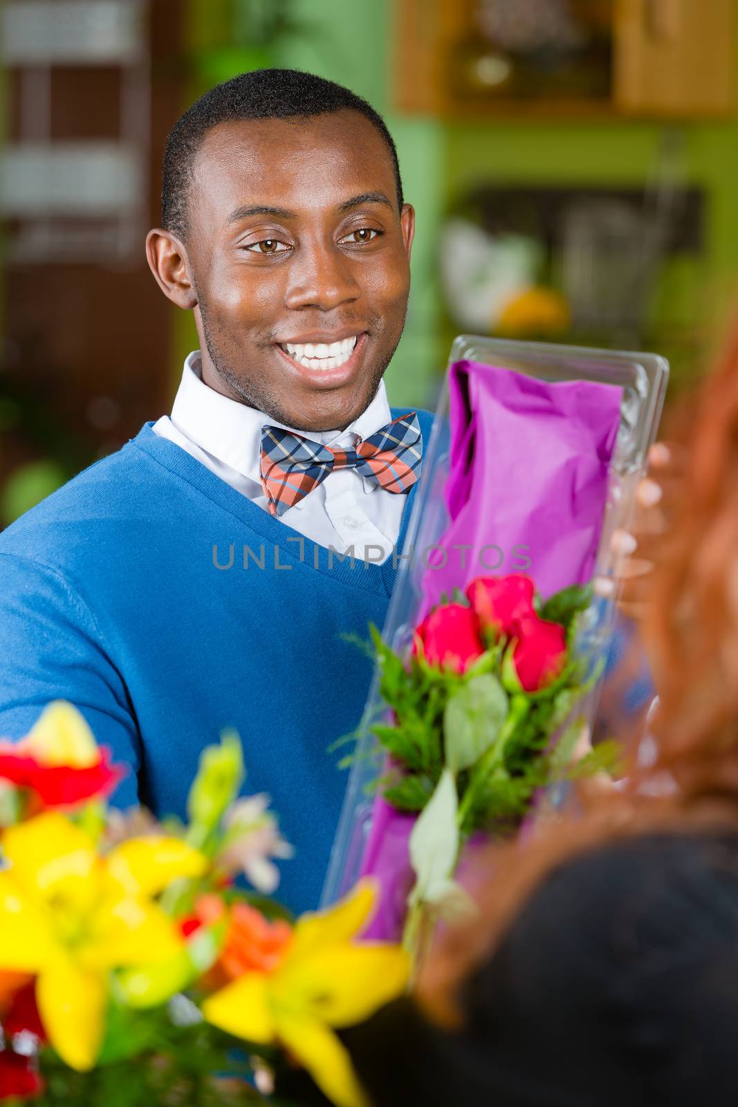 Handsome man purchasing roses at a florist shop