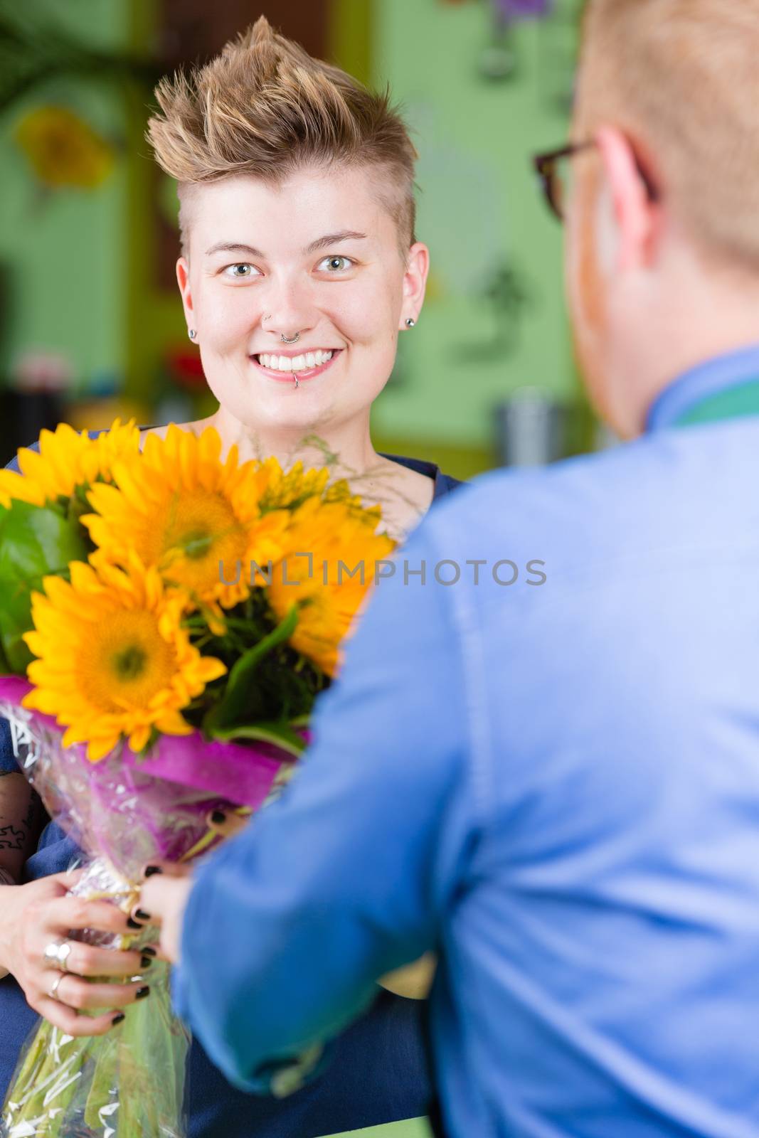 Pretty woman buying sunflowers at a florist shop