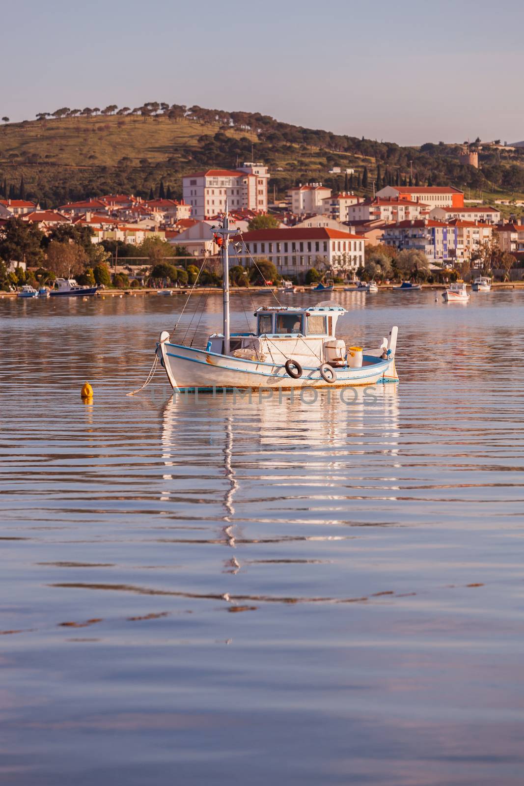 Small boat morred in front of Turkish coastal town of Ayvalik
