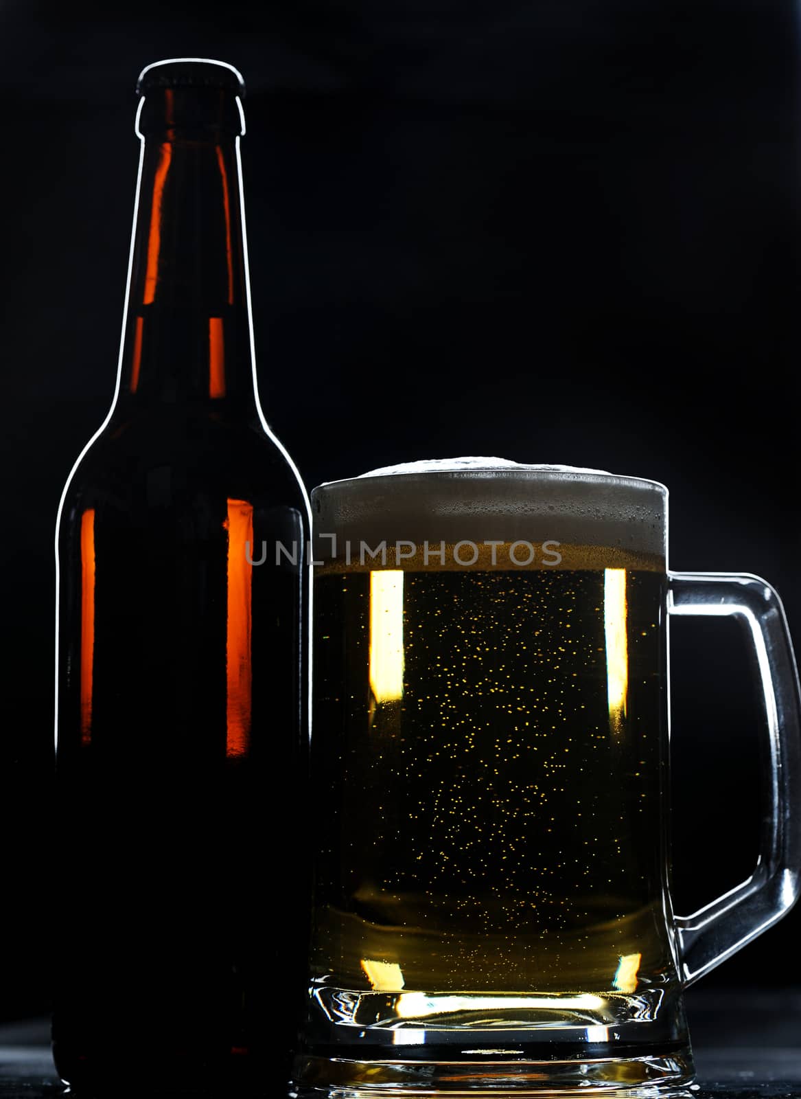 beer bottle and glass on black background