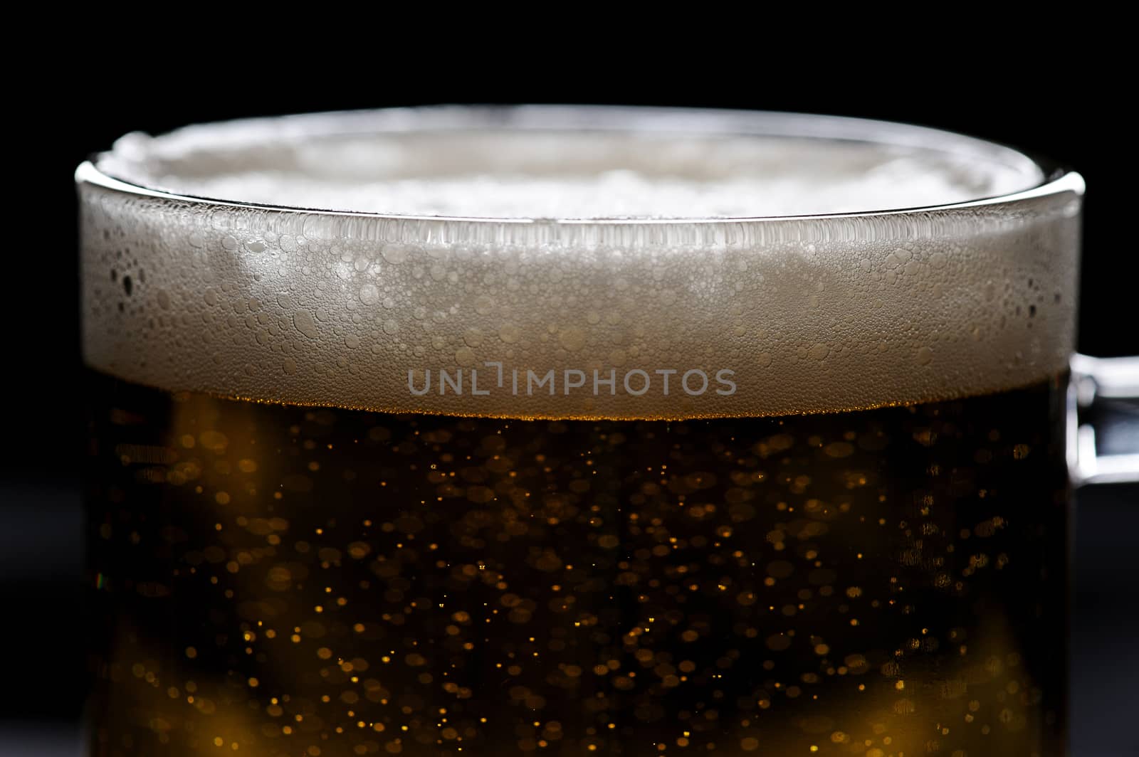 close up of bubbles on beer foam in glass