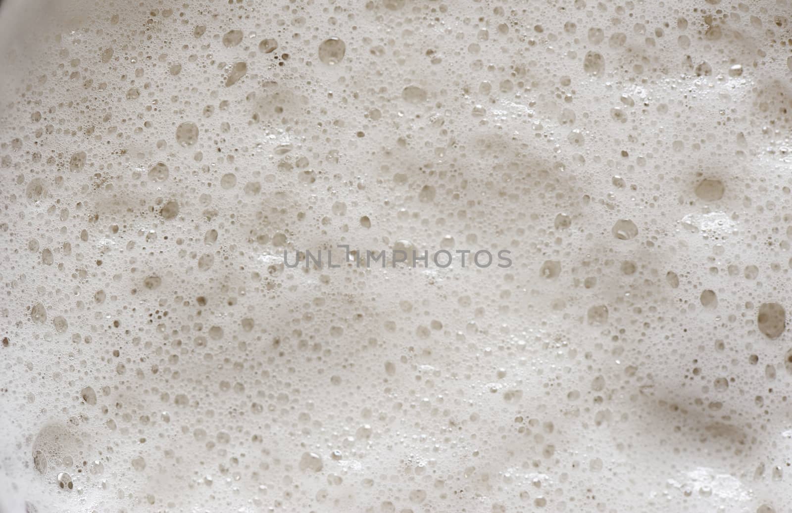 close up of small bubbles on beer foam in glass