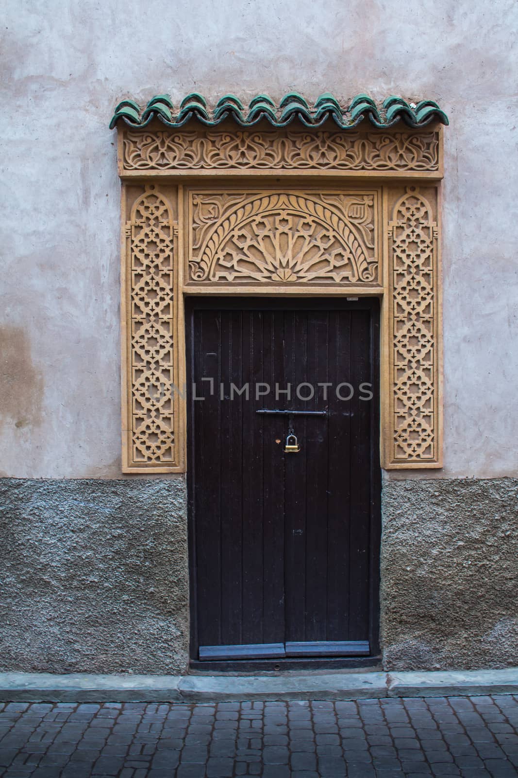 Traditional gate in the medina of Marrakesh during dawn. Beauty of the details of the decoration of the gate.