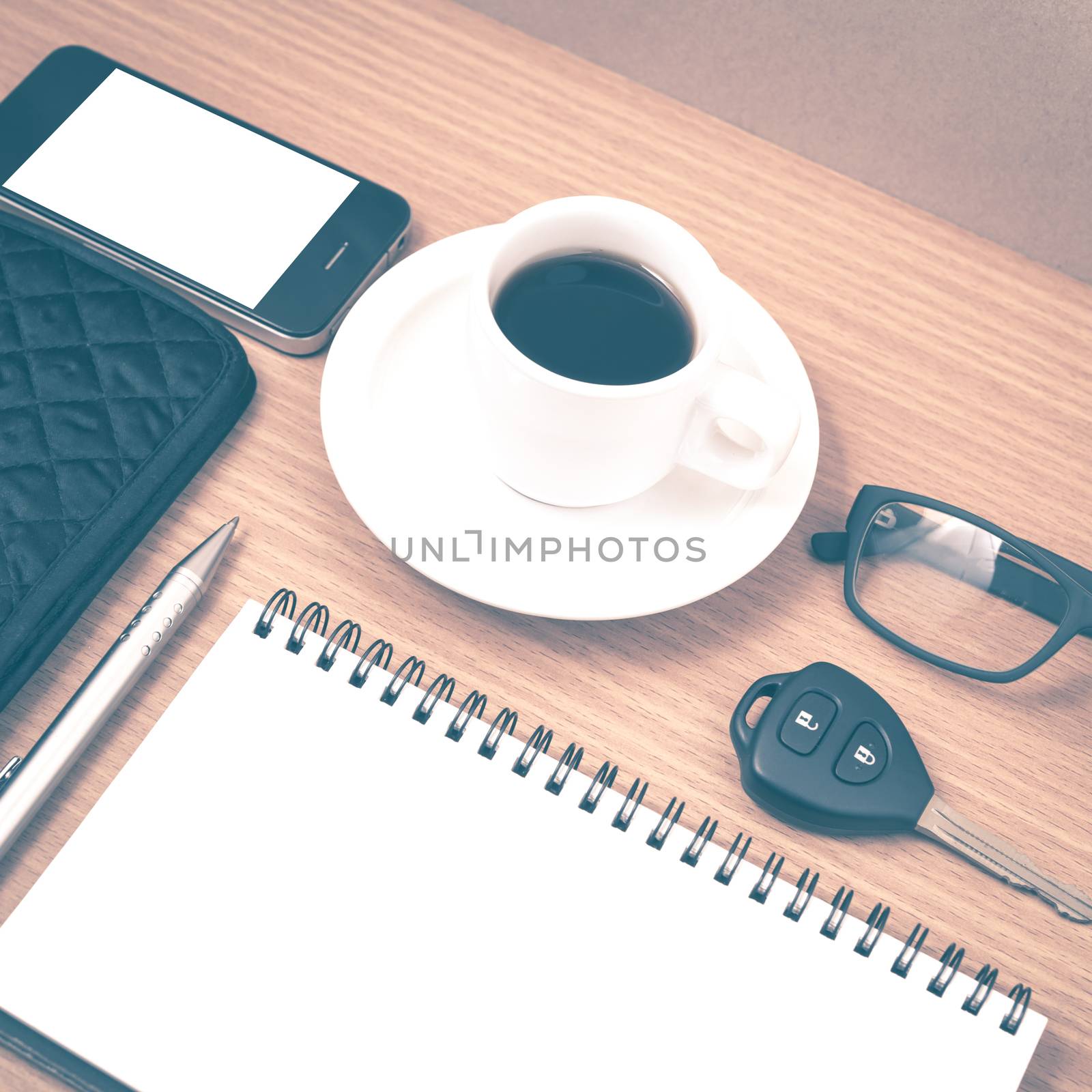 coffee and phone with notepad,car key,eyeglasses and wallet on wood table background vintage style