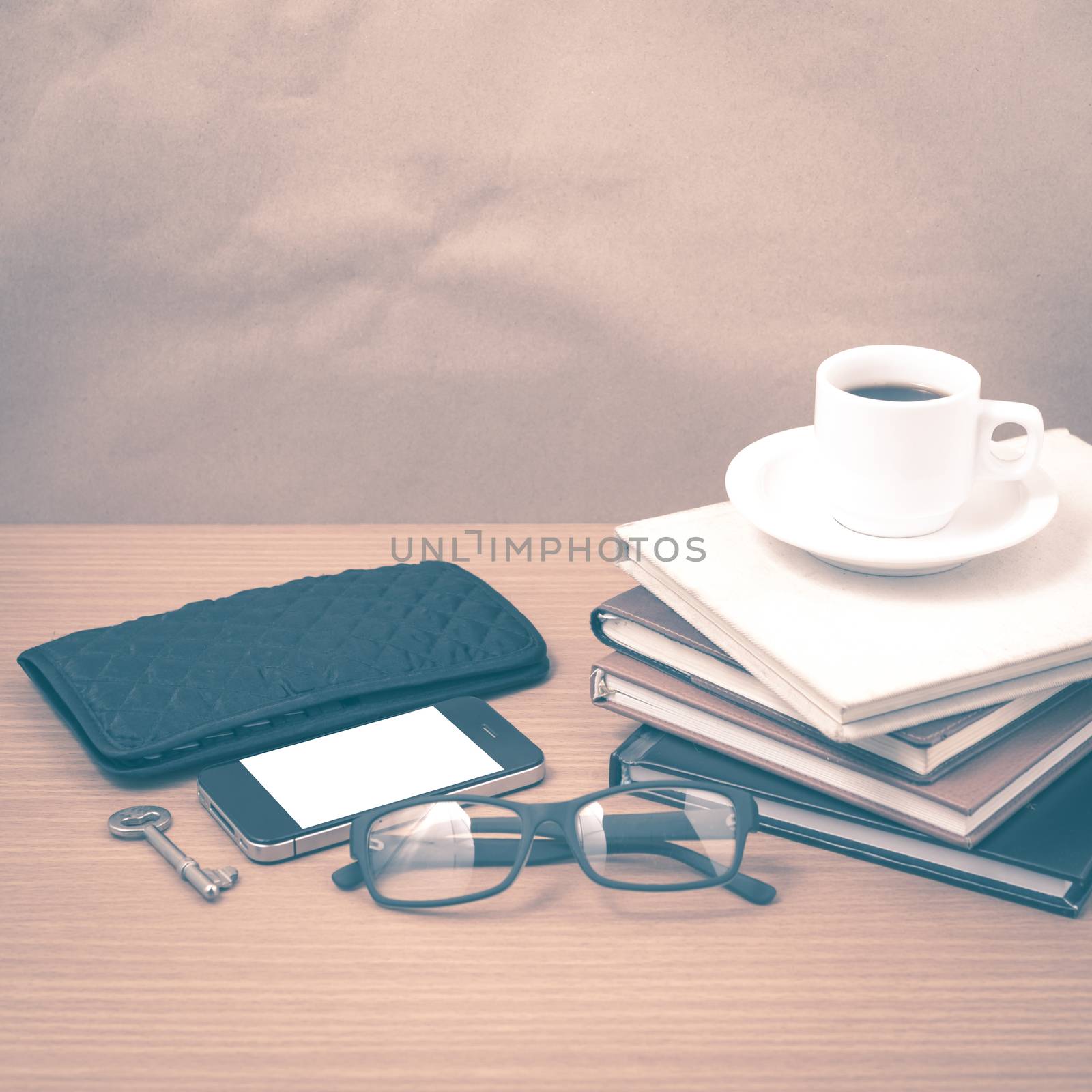 coffee and phone with stack of book,key,eyeglasses and wallet on wood background vintage style