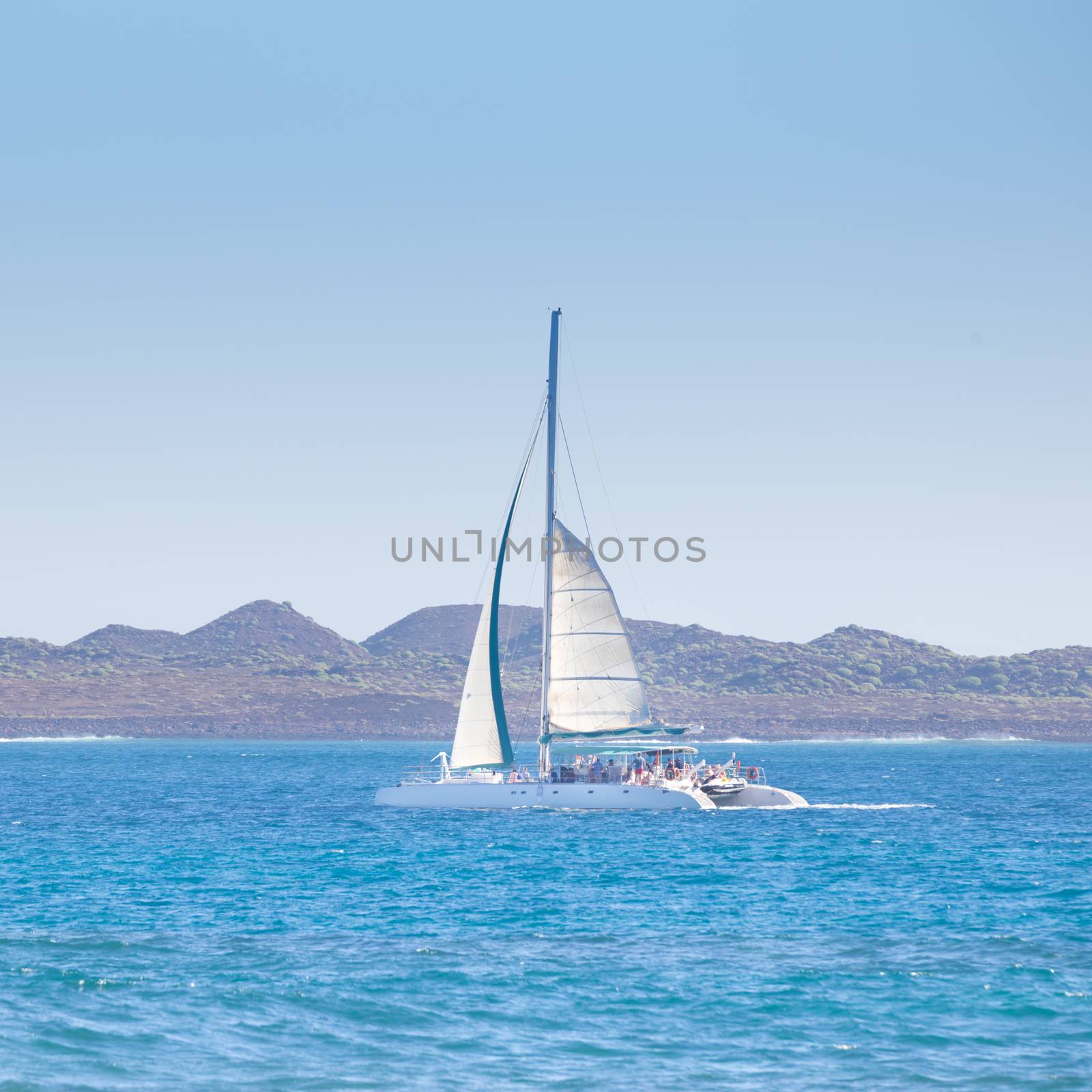 Catamarans cruising the blue sea. by kasto