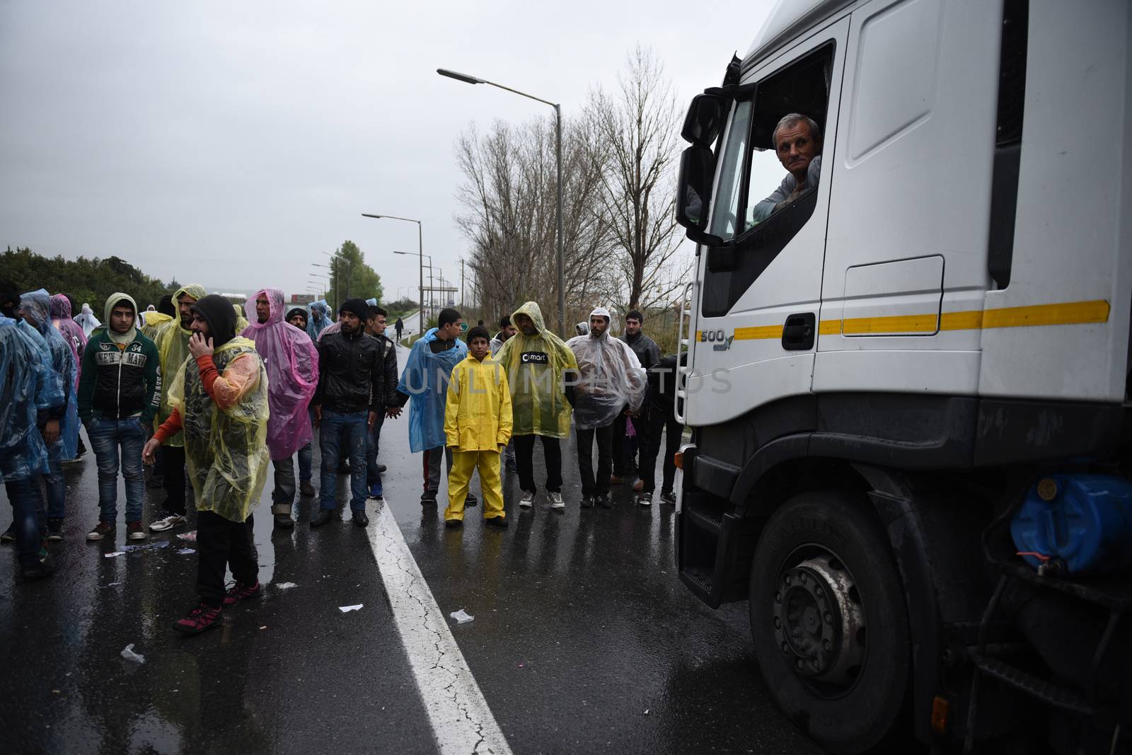 GREECE, Idomeni: A truck driver looks out from his cab at demonstrators blocking the road on March 23, 2016.Refugees and migrants blocked the main highway road near the northern Greek village of Idomeni at the Greek-Macedonian border, cutting off traffic between Greece and Macedonia, on March 23, 2016. People demonstrated demanding for the border to open, in order to continue their trip to northern Europe.